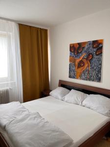 美因河畔法兰克福Apartment的卧室配有一张白色床,墙上挂有绘画作品