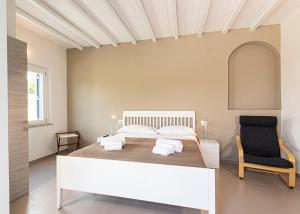 拉科纳B&B Villa Costanza的卧室配有白色的床和黑椅