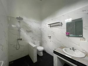 MuntokPondok Sahang Cottages的白色的浴室设有卫生间和水槽。