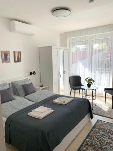 凯斯特海伊Villa Lillybeth - Lake Balaton的一间卧室配有一张大床和两条毛巾