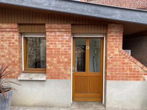 里尔Chez Jérôme的砖屋,设有木门和两扇窗户
