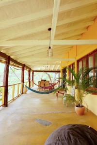 普拉纳维瑙Venao Surf Lodge的大房间,房子里设有吊床