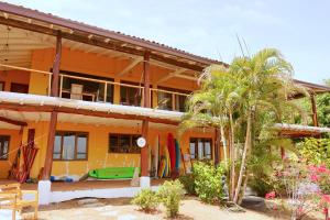 普拉纳维瑙Venao Surf Lodge的旁边设有冲浪板的房子