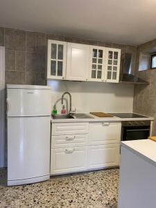斯塔利格拉德-帕克利尼卡Petite house的厨房配有白色橱柜和白色冰箱。