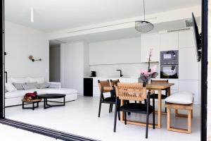 阿约斯尼奇塔斯Mandevilla Hillside Luxury Villas的厨房以及带桌椅的起居室。