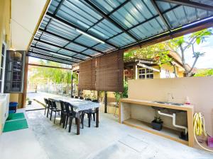 瓜拉丁加奴Ujana Damai - Cosy 5 bedrooms near UMT UNISZA的庭院配有桌椅和水槽。