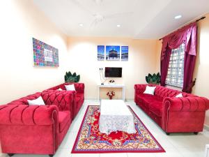 瓜拉丁加奴Ujana Damai - Cosy 5 bedrooms near UMT UNISZA的客厅配有两张红色的沙发和一张桌子