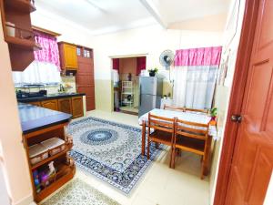瓜拉丁加奴Ujana Damai - Cosy 5 bedrooms near UMT UNISZA的厨房配有桌子和冰箱