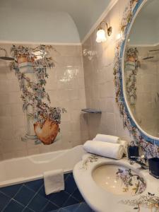 普莱伊亚诺Palazzo Rocco - Golden Suite - Praiano - Amalfi Coast的浴室配有盥洗盆、镜子和浴缸