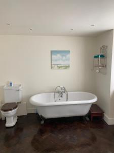 BanhamBluebell Barn的浴室配有白色浴缸和卫生间。