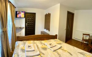阿尔杰什河畔库尔泰亚Casa de sub Salcie的一间卧室配有一张床,上面有两条毛巾