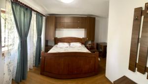 阿尔杰什河畔库尔泰亚Casa de sub Salcie的一间卧室设有一张木床和一个窗户。