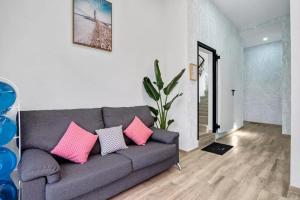 阿利坎特Umihouse apartamentos centro Alicante的客厅配有带粉红色枕头的灰色沙发