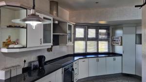 拉姆斯盖特LookOut Ramsgate的厨房配有白色橱柜和黑色台面