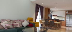 吉隆坡Anggun Residences 1500sqft 3BR KL TOWER KLCC的一间带绿色沙发的客厅和一间厨房