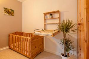 格罗尔斯泰因Ferienwohnung Airone Nero的一间有婴儿床的房间,里面装有植物