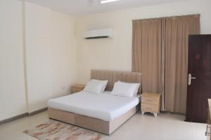 塞拉莱Aknan 01 - Center Market的一间卧室配有带白色床单和白色枕头的床。