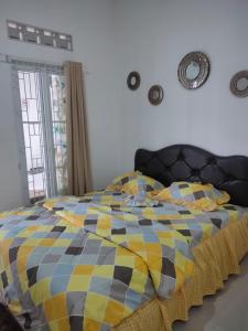 苏加武眉Nel's House Villa Jacuzzi Sukabumi的一间卧室配有一张带 ⁇ 子毯子的床
