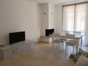 福利尼奥Casa Emilia - Appartamento per vacanze - Foligno的白色的客厅配有桌子和电视。