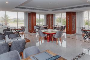塞拉莱Salalah International Hotel的用餐室设有桌椅和窗户。
