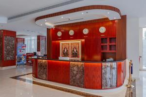 塞拉莱Salalah International Hotel的大堂设有墙上的带时钟的柜台