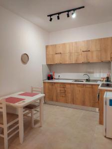 地拉那Gex apartments的厨房配有木制橱柜、桌子和水槽。