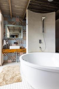 派尔努Cube house的一间带大型白色浴缸和镜子的浴室