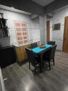 梅斯蒂亚Cottage - Location Lanchvali的一间配备有蓝色桌子和椅子的用餐室