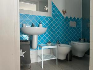 泰斯塔角Da Fede的蓝色瓷砖浴室设有水槽和卫生间