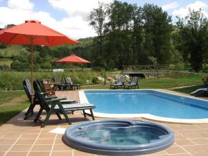 索托德坎加斯坎波之屋乡村酒店的一个带椅子和红伞的游泳池