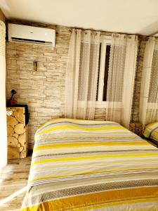 弗雷瑞斯Charmante maisonnette proche plage的一间卧室设有一张床和砖墙