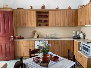 瓦西Mirsini Apartments的厨房配有木制橱柜和鲜花桌