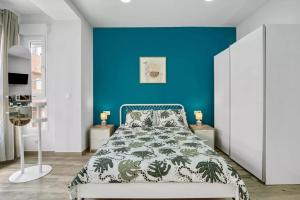 阿利坎特Umihouse apartamentos centro Alicante的一间卧室设有蓝色的墙壁和一张床
