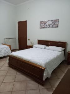 塔尔奎尼亚Casa Teresa的一间卧室配有一张带白色床单的大床