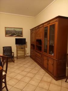 塔尔奎尼亚Casa Teresa的客厅设有大型木制橱柜和电视。