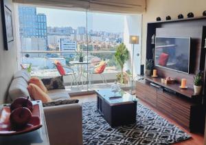 利马Exclusivo Departamento 2BR en San Isidro的一间带电视和大窗户的客厅