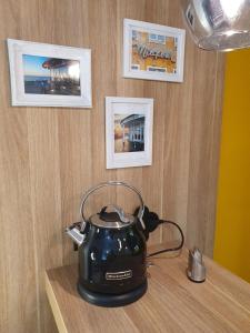 诺德奈Kleine Milchbar的木桌上的茶壶,墙上挂着照片