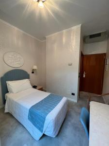 马尔切西内怡东湾酒店的酒店客房,配有一张带蓝色毯子的床