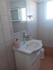 利普西岛Orizodas的白色的浴室设有水槽和镜子