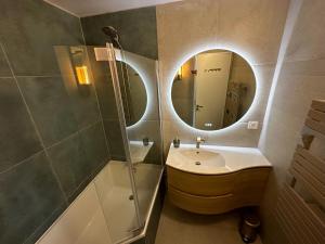 卡布尔Vue mer exceptionnelle à Cabourg的一间带水槽、淋浴和镜子的浴室