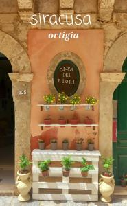锡拉库扎Casa dei fiori的花店的标志,花店有盆栽植物