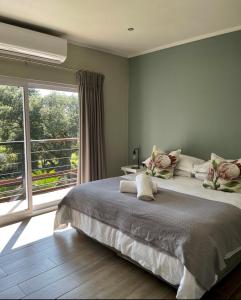 鲁德普特Serene Place Guest House & Conference Venue AFFORDABLE LUXURY WITH BACKUP POWER的一间卧室设有一张大床和一个大窗户