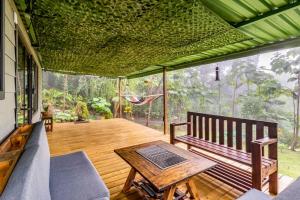 蒙泰韦尔德哥斯达黎加Tiny house Monteverde的门廊上设有长凳和桌子的屏风
