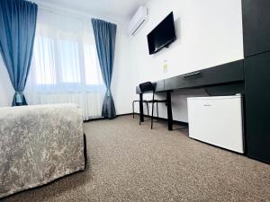 Tîrgu FrumosStef Rooms的一间卧室配有电视、一张床和一台电视机。
