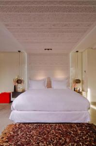 马拉喀什塞萨尔Spa度假酒店的卧室配有一张大白色的床和地毯