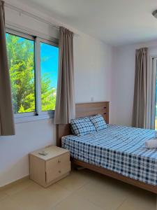 珊瑚湾3 Bedroom Coral Bay Beach Seaview Villa II Private Pool的一间卧室设有一张床和两个窗户。