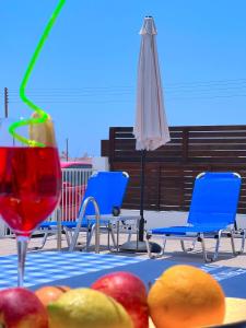 珊瑚湾3 Bedroom Coral Bay Beach Seaview Villa II Private Pool的一张桌子,上面有水果和饮料,还有一把雨伞