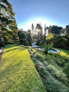 鲁德普特Serene Place Guest House & Conference Venue AFFORDABLE LUXURY WITH BACKUP POWER的一个带游泳池和草地的花园