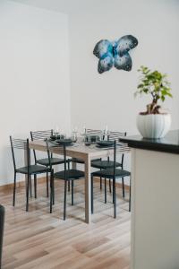 圣维托基耶蒂诺Casa vacanze La Farfalla的餐桌,配有黑色椅子和墙上的蝴蝶