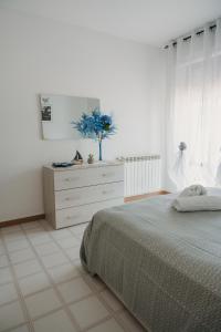 圣维托基耶蒂诺Casa vacanze La Farfalla的一间白色卧室,配有一张床和一个梳妆台